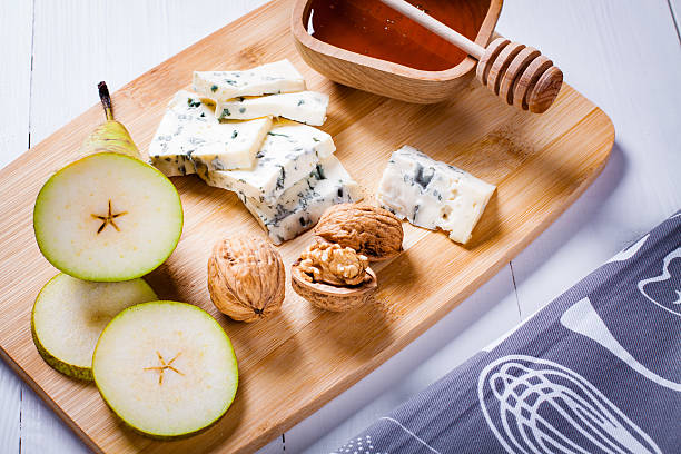 istock Blue cheese, pear, nuts and honey, bamboo wooden cutting board. 520221862