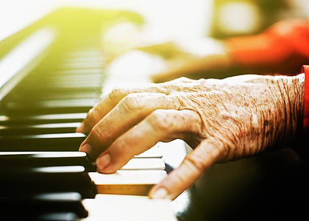 istock Old, wrinkled hands playing the piano 520223772