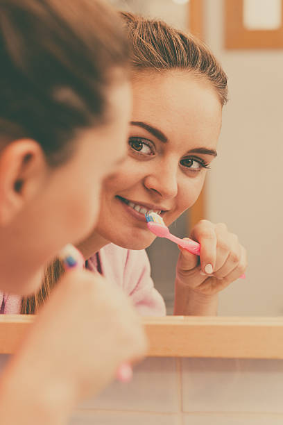 istock Woman brushing cleaning teeth in bathroom 520224804