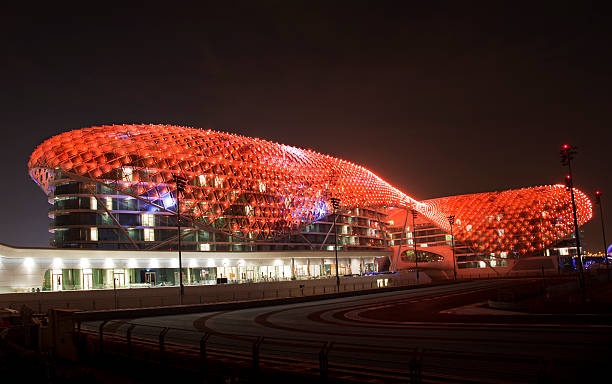 Abu Dhabi, UAE - November 19, 2013: Yas Island Viceroy Hotel at night. A night view of the Yas Hotel - the iconic symbol of Abu Dhabi's Grand Prix. It is the first new hotel in the world to be built over an F1 race circuit. The illuminated roof of the Yas Viceroy Hotel displaying one of its many colour schemes. 