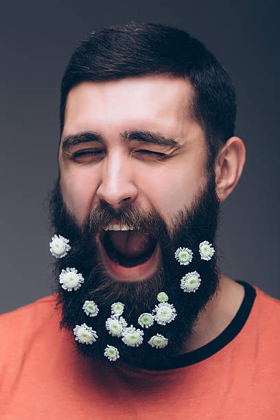 istock screaming young bearded hipster man with flowers in his beard 520229222