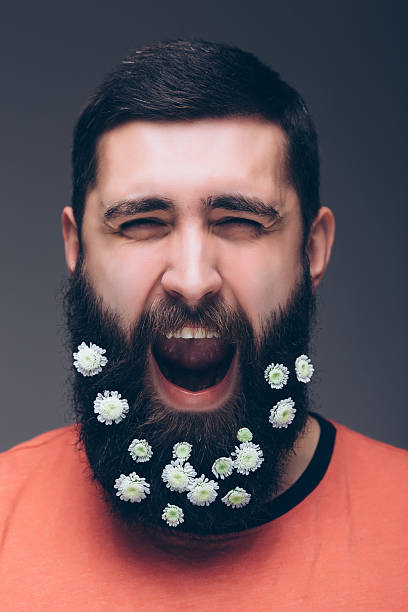 istock screaming young bearded hipster man with flowers in his beard 520229288