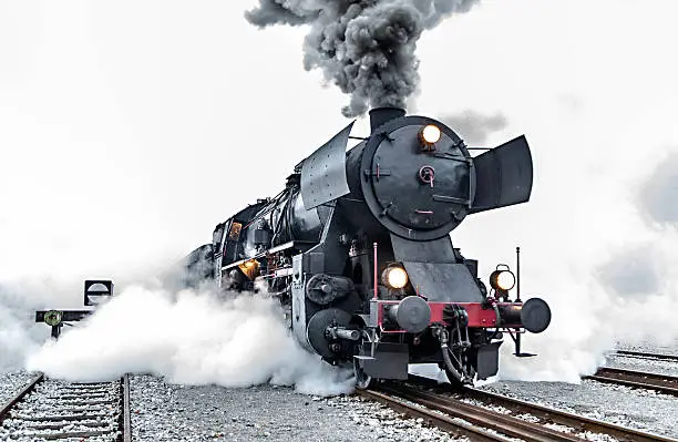 Old steam train leaving the railway station in Nova Gorica, Slovenia, Europe. Lots of black and gray steam hiding the locomotive, full frame, XXXL