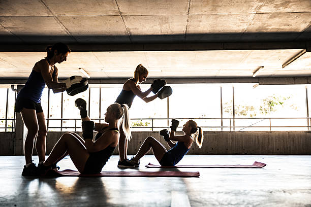 Women only boxing team exercising outdoor Group of women sport team boxing outdoor inside a multi level parking in Australia. sports training australia stock pictures, royalty-free photos & images