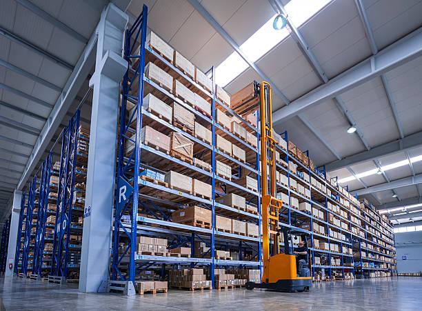 istock Forklift Lifting a cardboard box in warehouse aisle 520230804