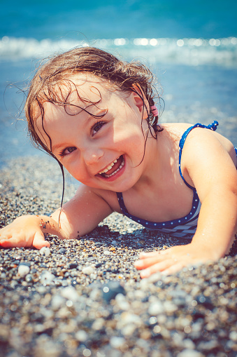 Happy little girl having fun near the sea
