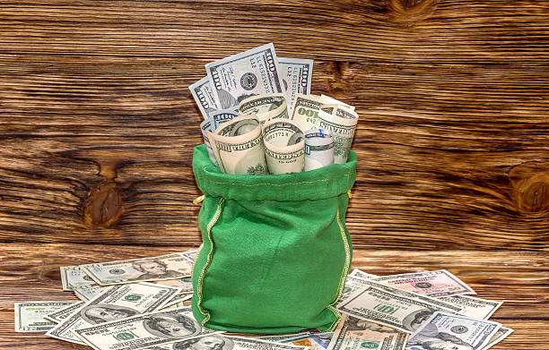 istock Sack with dollars on wooden background 520234536
