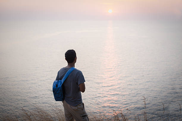 istock solo traveler watching beautiful sunset on the cliff 520236202