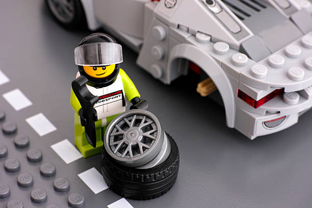 lego conducteur figurine est la réparation de roue de porsche 918 spyder - formula one racing photos et images de collection