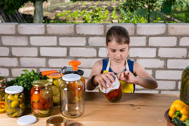 menina jovem canning compotas de legumes frescos - jar canning food preserves - fotografias e filmes do acervo