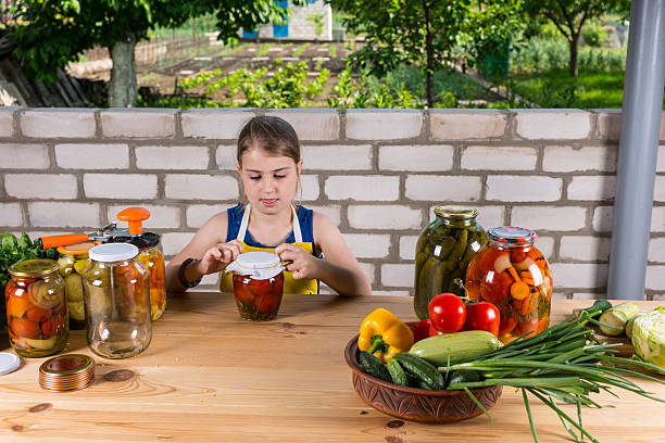 menina jovem canning compotas de legumes frescos - jar canning food preserves - fotografias e filmes do acervo