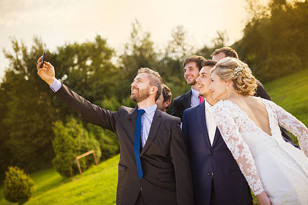 Bride with groom and his friends taking selfie