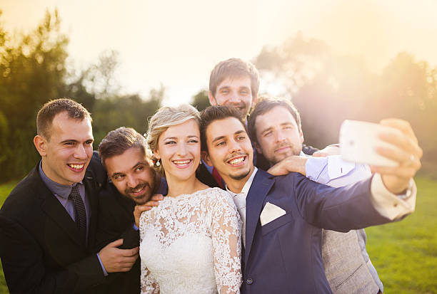 Bride with groom and his friends taking selfie Outdoor portrait of beautiful young bride with groom and his friends taking selfie wedding photos stock pictures, royalty-free photos & images