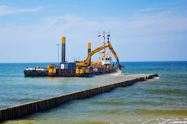 industrial lastkahn mit einem excavator auf das meer - industrial ship earth mover barge yellow stock-fotos und bilder