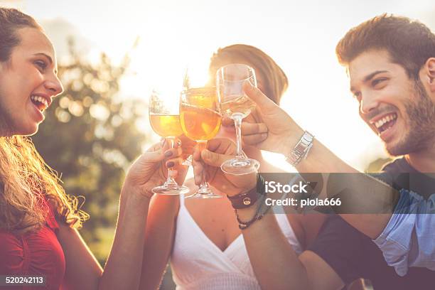 Group Of Friends Drinking Wine In Cheerful Moment Stock Photo - Download Image Now - Aperitif, Cocktail, Friendship