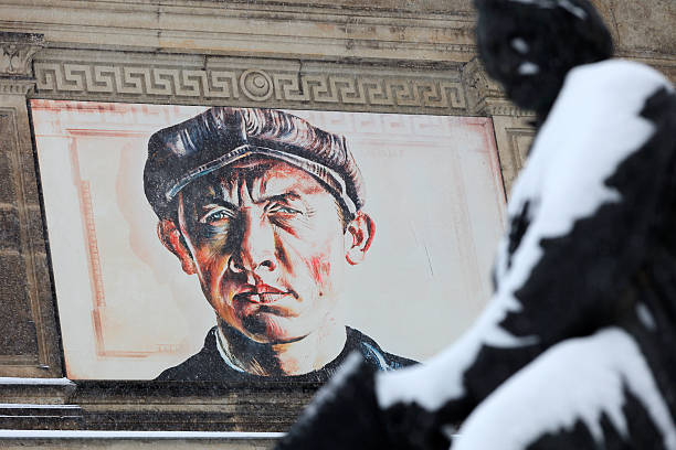Dresden, Germany - February 23, selfportrait (1930) of Curt Querner (1904-1967) on the facade of Galerie Neue Meister on BruhlscheTerrace in Dresden on a cold winter day with statue of the German architect Gottfried Semper (sculptor: Johannes Schilling 1828-1910) out of focus in the foreground.