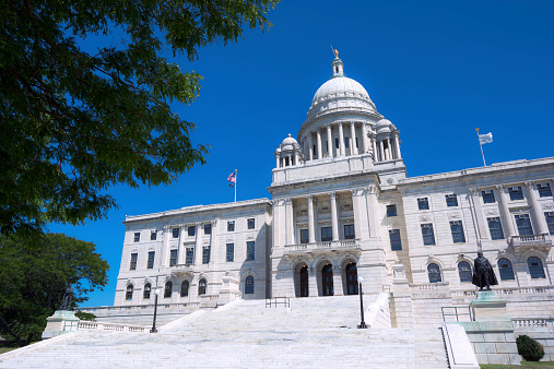 Providence, United States - August 9, 2014: The entrance to the Rhode Island State Capitol is seen during the daytime. The building is the seventh state capitol building for Rhode Island and second in the city of Providence. The building was completed in 1904 and houses the Rhode Island General Assembly, the offices of the governor of Rhode Island, the lieutenant governor, secretary of state, and general treasurer of Rhode Island.