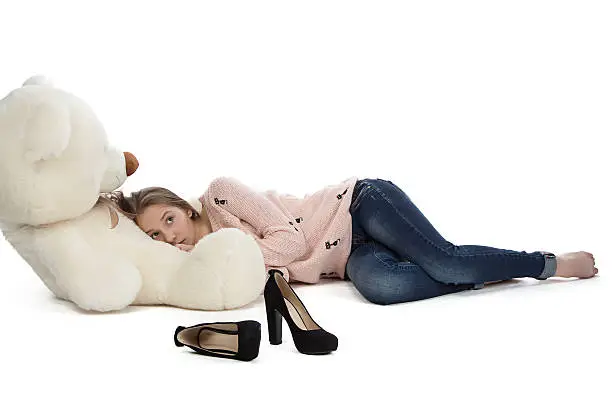 Photo of Image of teenage girl lying with teddy bear