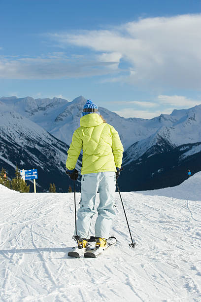 istock Woman skiing down slope, rear view 520260761