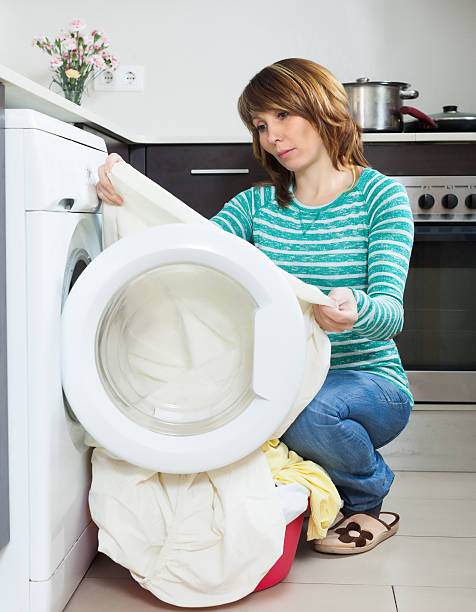 istock Unhappy  girl using washing machine at home 520262565