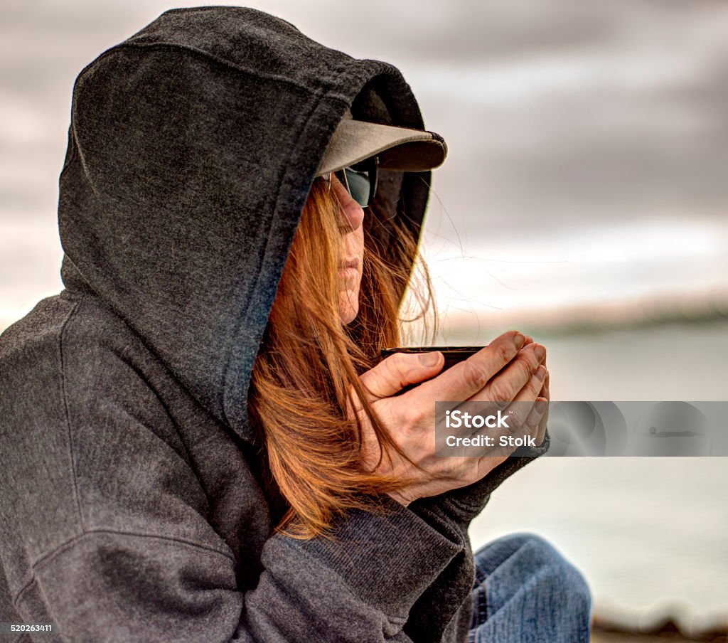 Closeup depressed woman with coffee A portrait of a depressed woman on a bench drinking coffee. Nikon D800, Nikkor 50mm, ISO 100 Adult Stock Photo