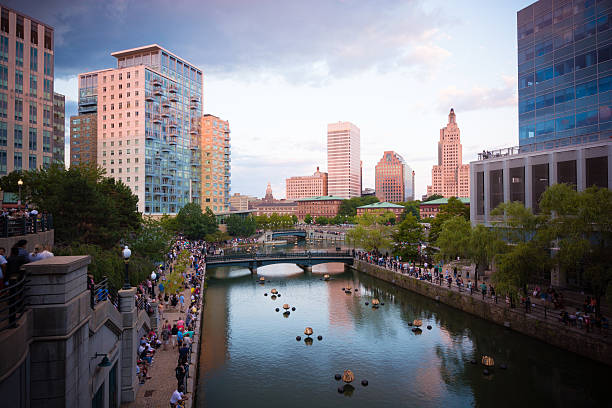 Crowds gather along Woonasquatucket river in Providence, RI Crowds gather along Woonasquatucket river in Providence, RI in preparation for the summer series known as WaterFire, which consists of fiery wooden blocks placed along the river during the nighttime. providence rhode island stock pictures, royalty-free photos & images