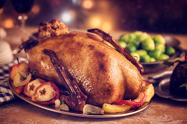tradicional británica holiday ánsar la cena con manzanas y bruselas sprouts - goose roasted goose meat spit roasted fotografías e imágenes de stock