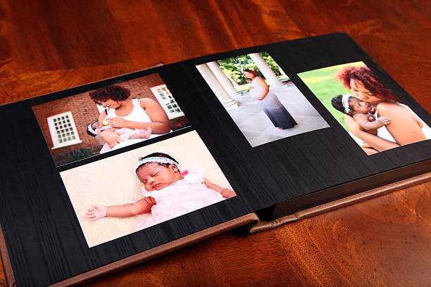 Memories Open photo album with photos of keepsakes of a new birth. old black leather photo album stock pictures, royalty-free photos & images