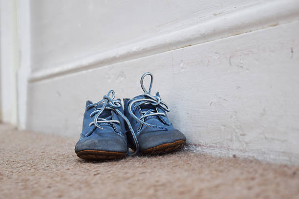 istock Baby's blue shoes on the carpet 520286374