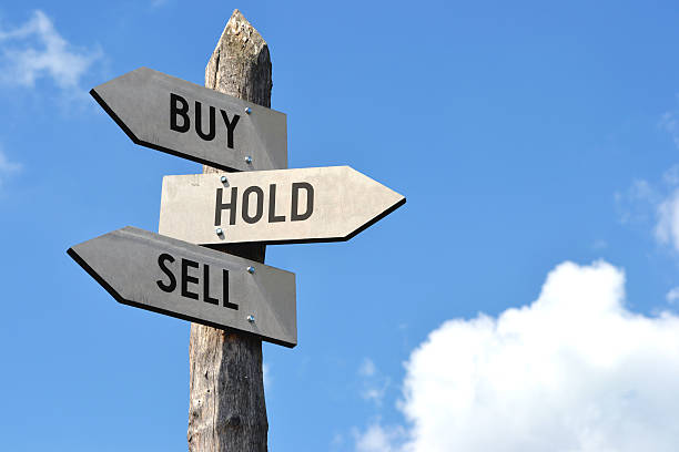 Wooden signpost - buy, hold, sell stock photo