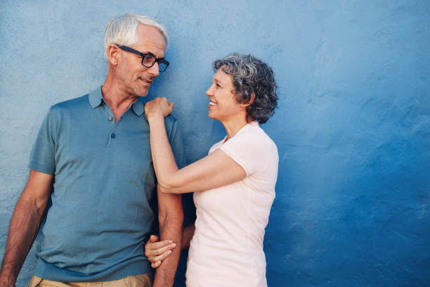istock Romantic couple standing together against a blue wall 520292614