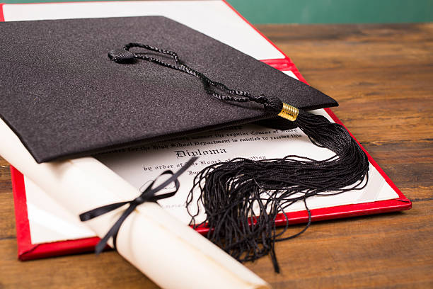 istock Graduation!  Cap, motarboard and tassel with dilplomas on table. Education. 520292654