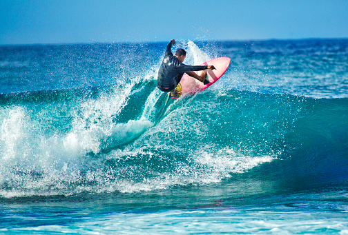 Young surfer surfing the wave of Kauai, Hawaii, USA.