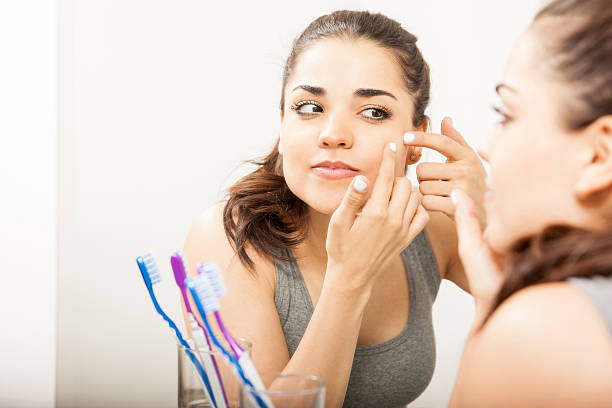 istock Cute woman looking at a pimple 520293156