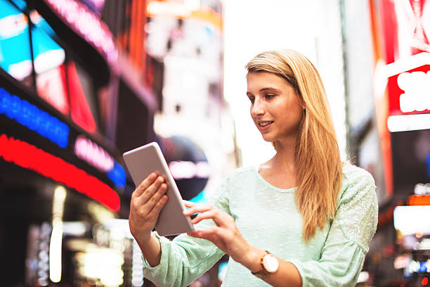 frau mit dem laptop in times square-new york city - digital tablet travel destinations new york state times square stock-fotos und bilder