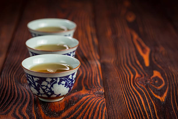 istock Cups with green tea on wooden background 520293536