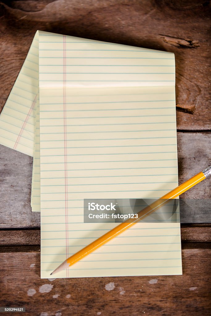 Blank, yellow notepad and pencil on wooden table. Business, education. Business or education concepts. Copyspace on blank yellow notepad with pencil.  Rustic wooden table background.  Absence Stock Photo