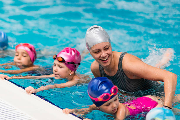 Swimming school Swimming school - Swimming instructor with children swimming stock pictures, royalty-free photos & images