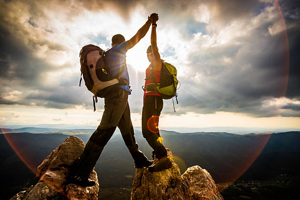 couple sur une montagne secouer soulevées mains - outdoor pursuit photos photos et images de collection