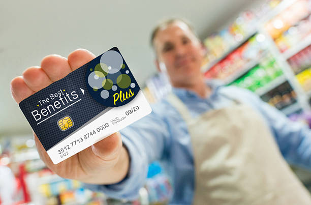 istock Man at a store holding a loyalty card 520297190