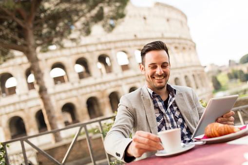 Young man sitting and having a cup of coffee in Rome, Italy