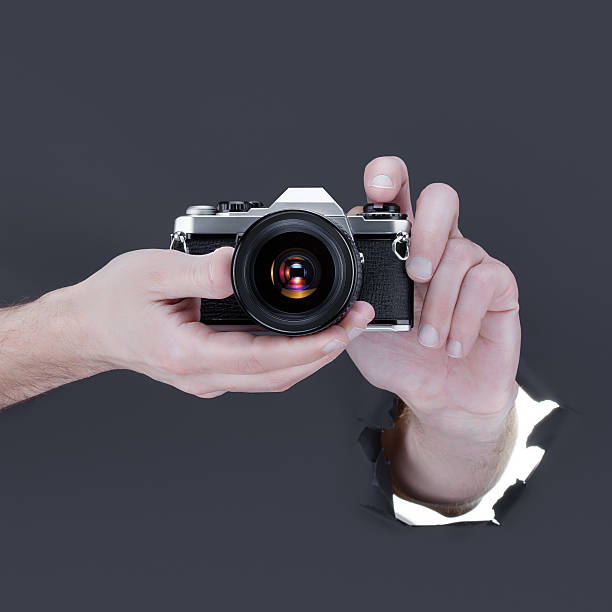 istock Male hand breaking through the black paper background 520298106
