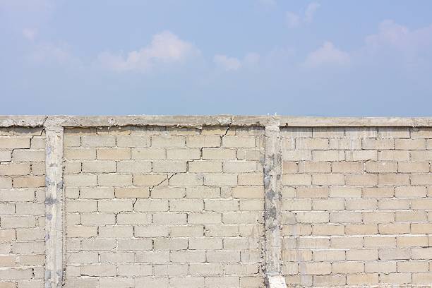 istock cracked wall in the background of cloud and sky 520298319