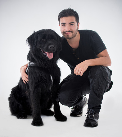 Beautiful black dog with his owner looking at the camera smiling
