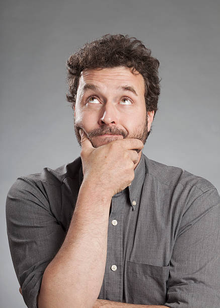 istock Man in grey shirt looking up, doubting 520325081