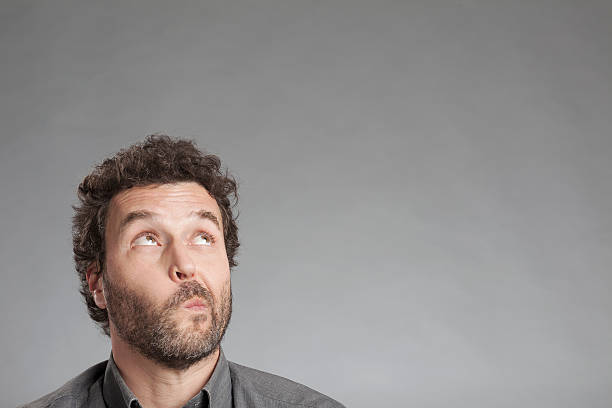 istock Man in grey shirt looking up 520325121