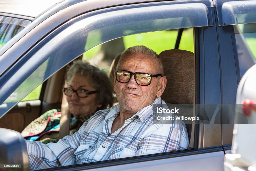 Senior Couple Funny Faces In Car Elderly senior adult married heterosexual couple - 89 and 87 years old - making funny grimace faces for the camera as they drive past the rural streetside mailbox in their trusty, well-worn car. Strongest focus on the man. Car Stock Photo