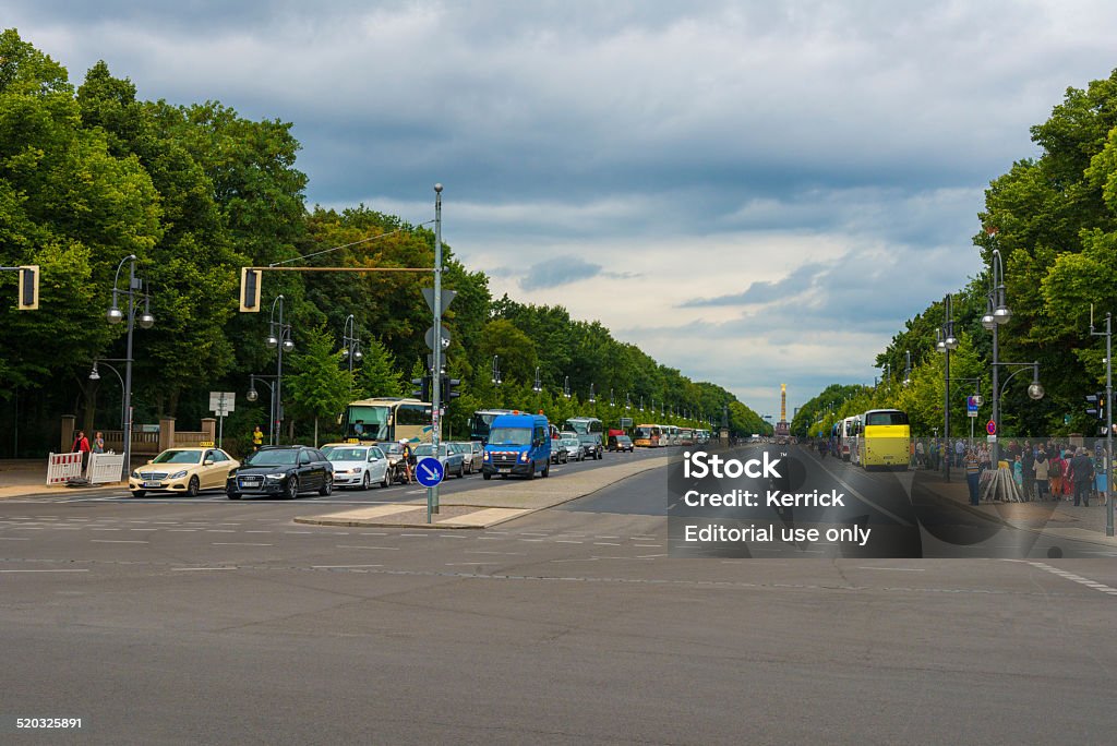 view to Strasse des 17. Juni in Berlin Berlin, Germany - August 12, 2014: view to the Strasse des 17. Juni in Berlin, Germany. In the far visible the Siegessäule.  a lot of cars standing at traffic light, people waiting Berlin Stock Photo