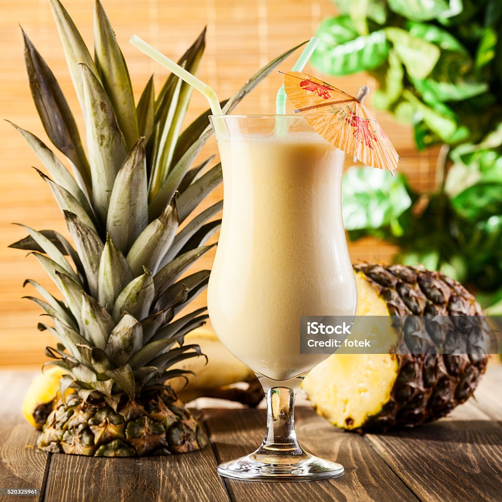 Piña Colada sobre fondo de madera decorado de piña - Foto de stock de Piña colada libre de derechos