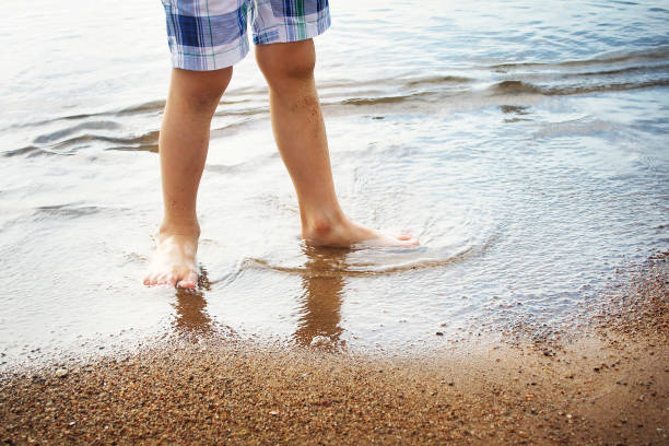 istock Boy's feet in the sea 520326155